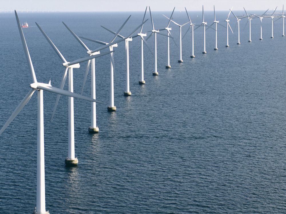 Offshore wind turbines against a clear sky.